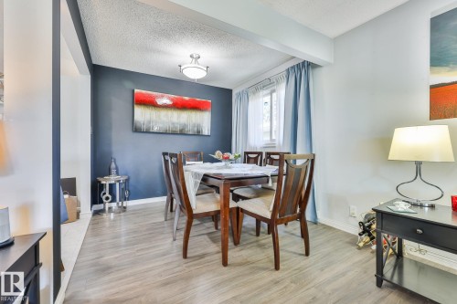 Wood-finish flooring throughout, featuring a window with a curtain rod, and a ceiling-mounted light fixture - 8932 187 Street Nw, Edmonton, AB - Indoor Photo Showing Dining Room