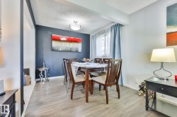 Wood-finish flooring throughout, featuring a window with a curtain rod, and a ceiling-mounted light fixture - 