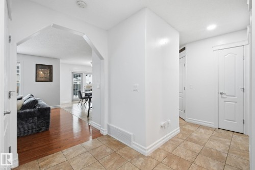 Arched entryway leading to a living area with wood-finish flooring - 3016 24 Ave Nw, Edmonton, AB - Indoor Photo Showing Other Room