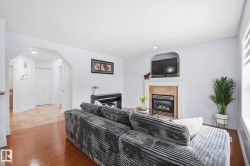 Wood-finish flooring, recessed lighting, arched entryway, built-in fireplace with hearth, and window with blinds - 