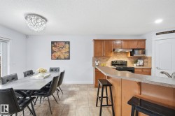 Kitchen with wood cabinetry, integrated microwave, and a breakfast bar with stone-finish countertops - 