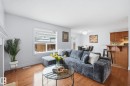 Wood-finish flooring throughout, white wall paint, and a window with blinds - 3016 24 Ave Nw, Edmonton, AB  - Indoor Photo Showing Living Room 
