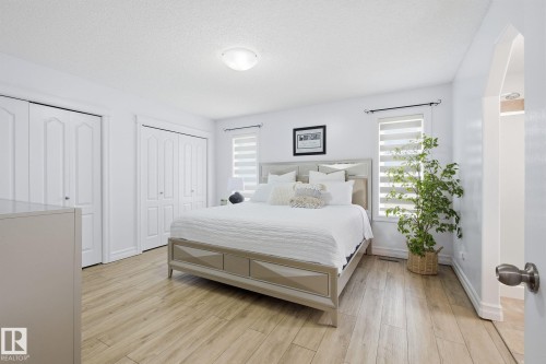Wood-finish flooring, white walls, and multiple windows with horizontal blinds - 3016 24 Ave Nw, Edmonton, AB - Indoor Photo Showing Bedroom
