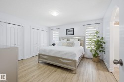 Wood-finish flooring, white walls, and multiple windows with horizontal blinds - 