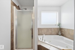 Frosted glass shower enclosure, corner soaking tub, and tile surround - 