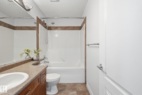 Built-in vanity with integrated sink, wood-finish cabinetry, and a neutral countertop - 3016 24 Ave Nw, Edmonton, AB - Indoor Photo Showing Bathroom