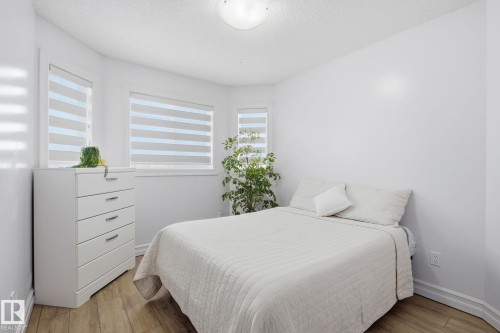 Bay window with layered window treatments and wood-finish flooring - 3016 24 Ave Nw, Edmonton, AB - Indoor Photo Showing Bedroom
