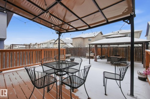 Wood-finish deck with a permanent overhead canopy, string lighting, and a partial wood railing - 3016 24 Ave Nw, Edmonton, AB - Outdoor With Deck Patio Veranda With Exterior