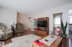 Living area featuring wood-finish flooring, textured wall finishes, and a neutral ceiling - 