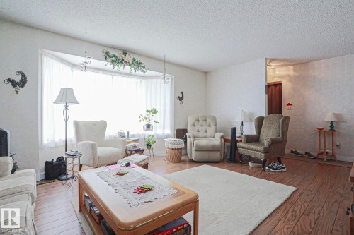 Living area featuring wood-finish flooring and a textured ceiling - 5203 45 Street, Beaumont, AB - Indoor Photo Showing Living Room
