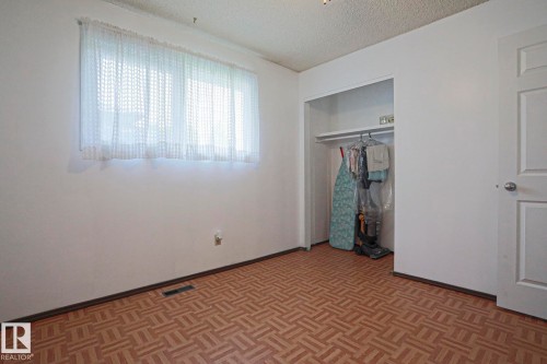Room featuring patterned wood-finish flooring, white walls, and a textured ceiling - 5203 45 Street, Beaumont, AB - Indoor Photo Showing Other Room