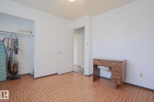 Room featuring patterned wood-finish flooring and white painted walls - 5203 45 Street, Beaumont, AB - Indoor