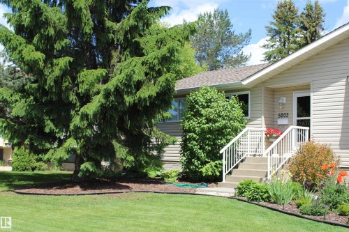 Front exterior with beige siding and a peaked roofline - 5203 45 Street, Beaumont, AB - Outdoor