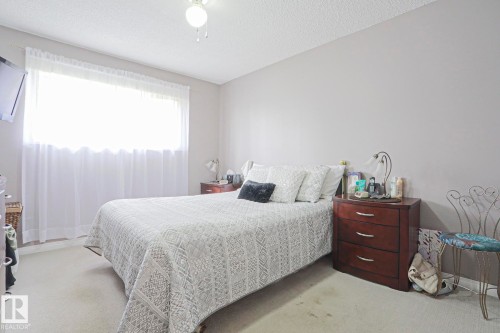 Carpeted room with light neutral wall paint and a window - 5203 45 Street, Beaumont, AB - Indoor Photo Showing Bedroom