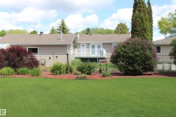 Expansive green lawn with established landscaping, including a mature flowering shrub - 