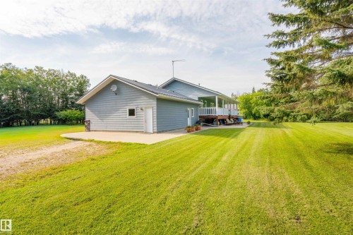 Expansive green lawn surrounds the property, featuring a light blue siding exterior with white trim - 59125 Range Road 102, Rural St. Paul County, AB - Outdoor