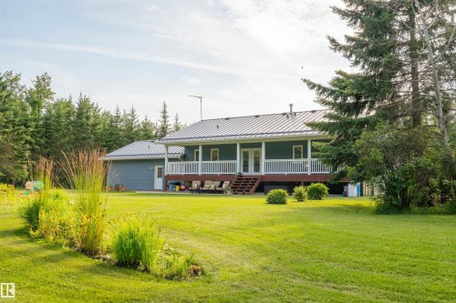 Expansive green lawn with mature trees bordering the property - 59125 Range Road 102, Rural St. Paul County, AB - Outdoor With Deck Patio Veranda
