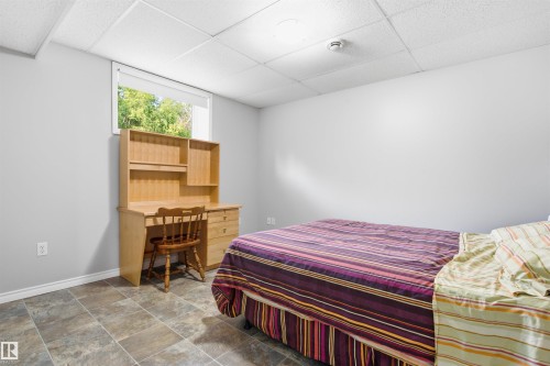 Bright room featuring a window with green outdoor scenery, light gray wall paint, white trim, and a drop ceiling - 59125 Range Road 102, Rural St. Paul County, AB - Indoor Photo Showing Bedroom