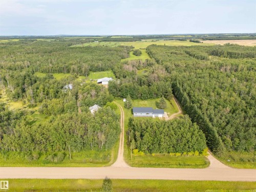 Expansive rural property featuring multiple structures, verdant treelines, and a gravel driveway system - 59125 Range Road 102, Rural St. Paul County, AB - Outdoor With View