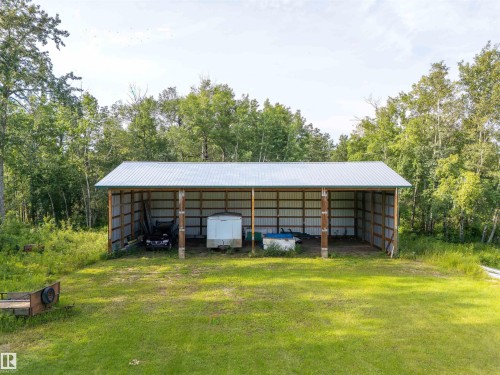 Open-sided shed featuring a metal roof and corrugated metal siding, supported by wood posts - 59125 Range Road 102, Rural St. Paul County, AB - Outdoor