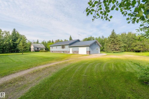Expansive green lawn surrounding a light blue residence with a dark metal roof - 59125 Range Road 102, Rural St. Paul County, AB - Outdoor