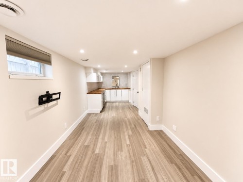 Recessed lighting illuminates the wood-finish flooring - 11934 64 Street Nw, Edmonton, AB - Indoor Photo Showing Other Room