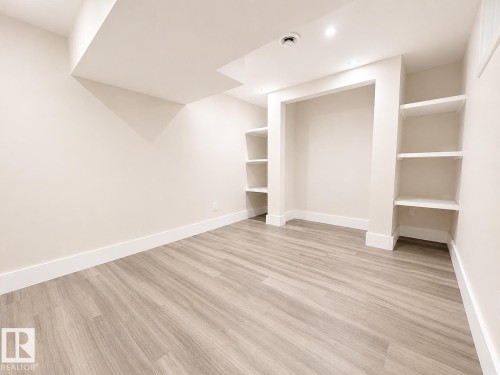 Recessed lighting, wood-finish flooring, built-in shelving, white trim, and neutral wall tones - 11934 64 Street Nw, Edmonton, AB - Indoor Photo Showing Other Room