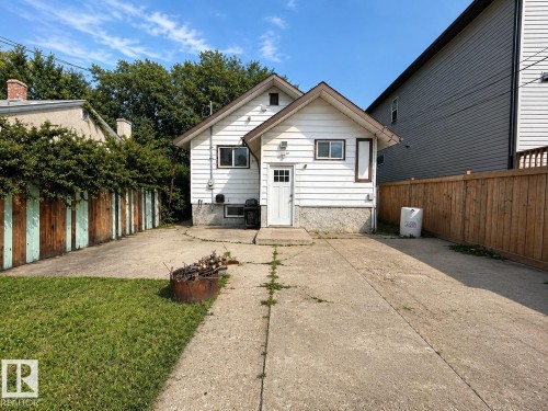White horizontal siding exterior with a concrete driveway and a wood privacy fence - 11934 64 Street Nw, Edmonton, AB - Outdoor