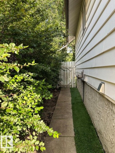 Concrete paver pathway with a white wooden gate - 11934 64 Street Nw, Edmonton, AB - Outdoor
