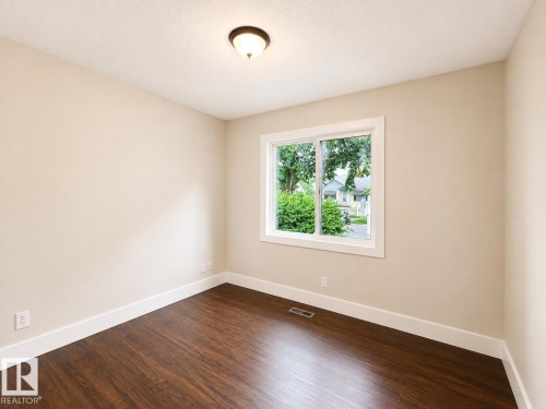 Recessed ceiling light, white trim, light-toned wall paint, wood-finish flooring, and white window frame - 11934 64 Street Nw, Edmonton, AB - Indoor Photo Showing Other Room