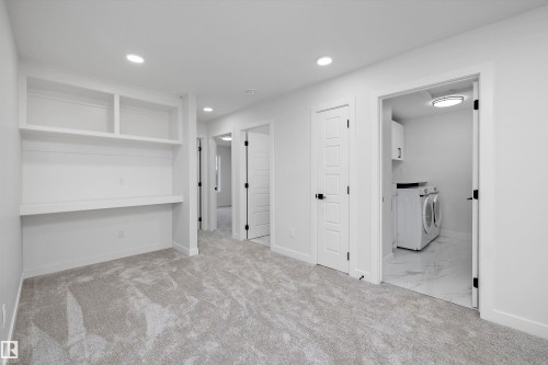 Built-in shelving and desk, recessed lighting, panel doors with matte black hardware, and carpet flooring - 971 Elderberry Landing Nw, Edmonton, AB - Indoor Photo Showing Other Room