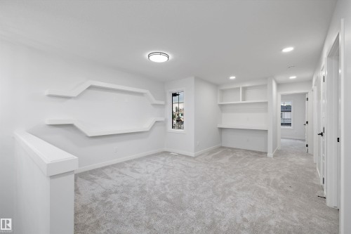 Neutral-toned carpeting throughout with built-in shelving, a dedicated desk area, and recessed lighting - 971 Elderberry Landing Nw, Edmonton, AB - Indoor Photo Showing Other Room