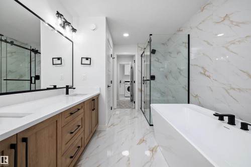 Dual vanity with wood-finish cabinetry, white countertops, and matte black fixtures - 971 Elderberry Landing Nw, Edmonton, AB - Indoor Photo Showing Bathroom