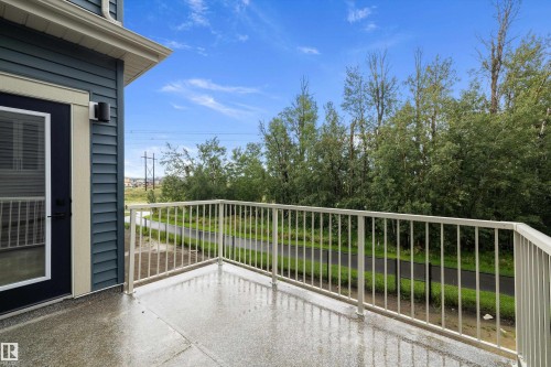 Exterior balcony with concrete flooring, white metal railing, and blue siding - 971 Elderberry Landing Nw, Edmonton, AB - Outdoor