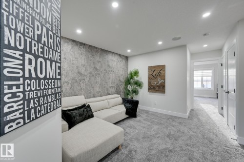 Recessed ceiling lighting, textured accent wall, plush carpeting, white trim, and doors with matte black hardware - 265 Edgemont Green Nw, Edmonton, AB - Indoor Photo Showing Other Room
