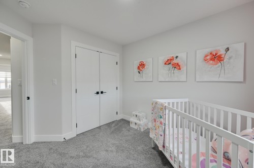 Plush grey carpet, white walls, and a double-door closet with black hardware - 265 Edgemont Green Nw, Edmonton, AB - Indoor Photo Showing Bedroom
