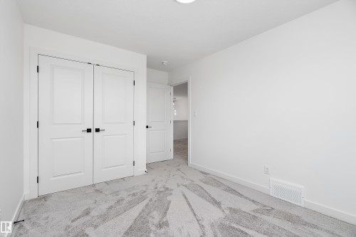 White walls with a light-colored carpet featuring a subtle pattern - 1763 Crossbill Loop Nw, Edmonton, AB - Indoor Photo Showing Other Room