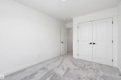 Light gray patterned carpeting, white walls, and white bi-fold doors with black hardware - 