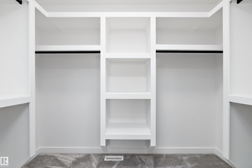 Built-in closet system with shelving and hanging rods - 1763 Crossbill Loop Nw, Edmonton, AB - Indoor With Storage
