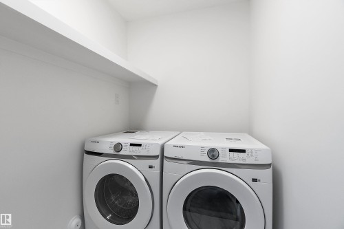 Built-in white shelving above appliances - 1763 Crossbill Loop Nw, Edmonton, AB - Indoor Photo Showing Laundry Room