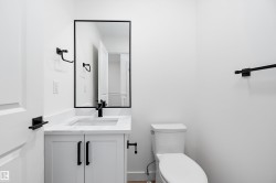 White vanity with matte black hardware, integrated rectangular sink, and stone-finish countertop - 