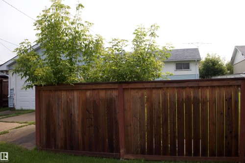 Wood privacy fence enclosing a paved driveway and detached garage - 4946 47 Street, Barrhead, AB - Outdoor
