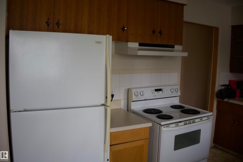 Wood-finish upper cabinetry with star-shaped hardware - 4946 47 Street, Barrhead, AB - Indoor Photo Showing Kitchen