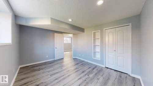 Recessed lighting, wood-finish flooring, built-in shelving, white trim, and a white interior door - 7848 7 Avenue Sw, Edmonton, AB - Indoor Photo Showing Other Room