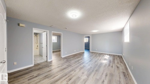 Spacious room featuring wood-finish flooring, light grey walls, and recessed lighting - 7848 7 Avenue Sw, Edmonton, AB - Indoor Photo Showing Other Room