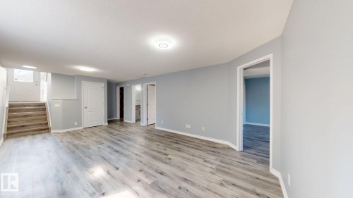 Expansive open living area featuring wood-finish flooring, light gray wall tones, and recessed lighting - 7848 7 Avenue Sw, Edmonton, AB - Indoor Photo Showing Other Room