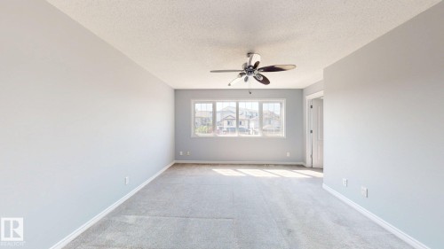 Spacious interior with neutral carpeting, large multi-pane windows, and a ceiling fan with integrated lighting - 7848 7 Avenue Sw, Edmonton, AB - Indoor Photo Showing Other Room