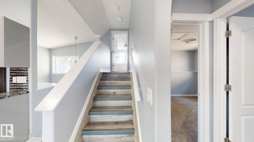 Wood-finish stairs with carpet runner, white railing, recessed lighting, and light-colored wall paint - 7848 7 Avenue Sw, Edmonton, AB - Indoor Photo Showing Other Room