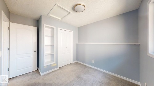 Built-in shelving, two panel doors, and a double-door closet - 7848 7 Avenue Sw, Edmonton, AB - Indoor Photo Showing Other Room
