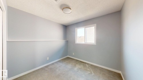 Carpeted flooring, light grey painted walls, horizontal wall trim, white window frame, and a flush mount ceiling light - 7848 7 Avenue Sw, Edmonton, AB - Indoor Photo Showing Other Room